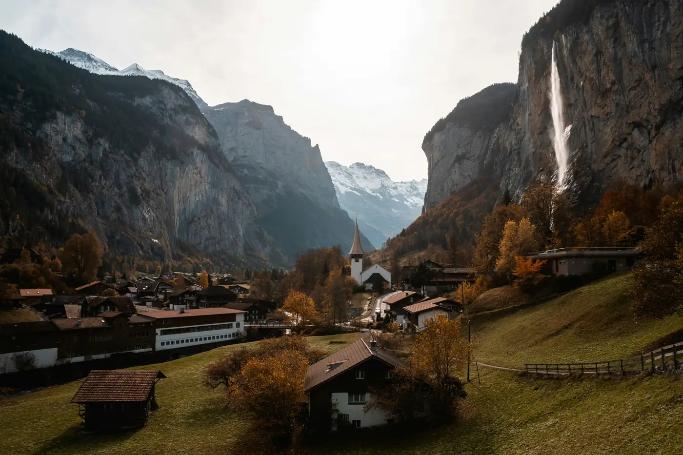 Bergdorp in de Alpen met een waterval op de achtergrond in de herfst