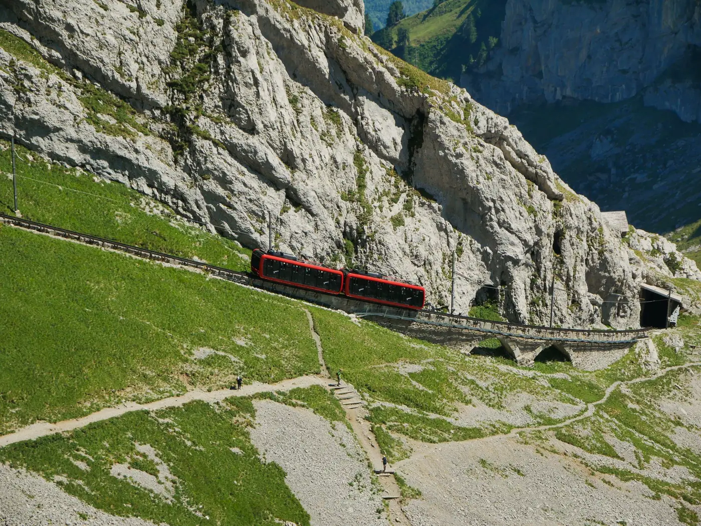 Rode tandradtrein die door de Zwitserse Alpen rijdt
