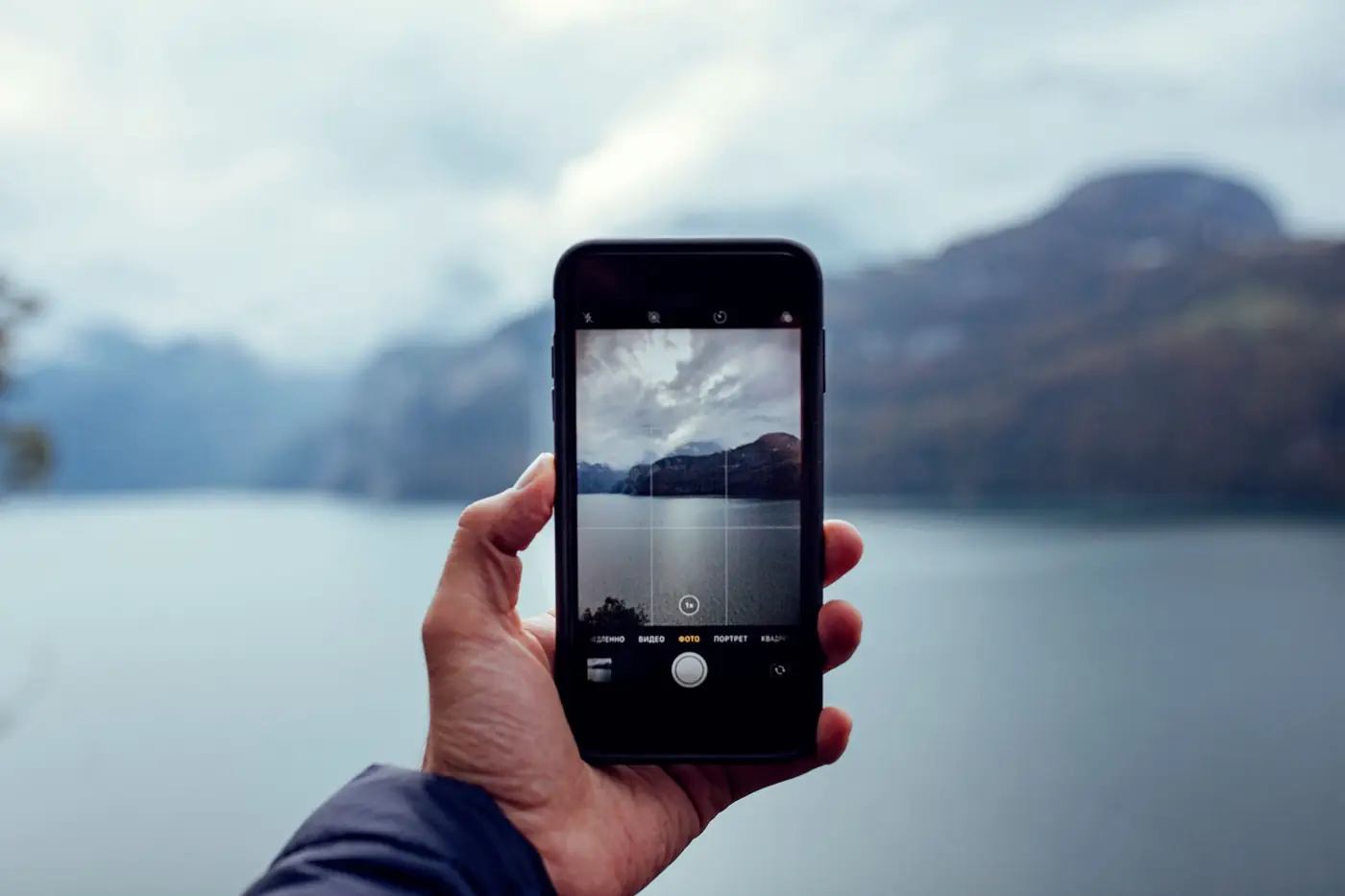 Iemand fotografeert een meer in Zwitserland met een smartphone