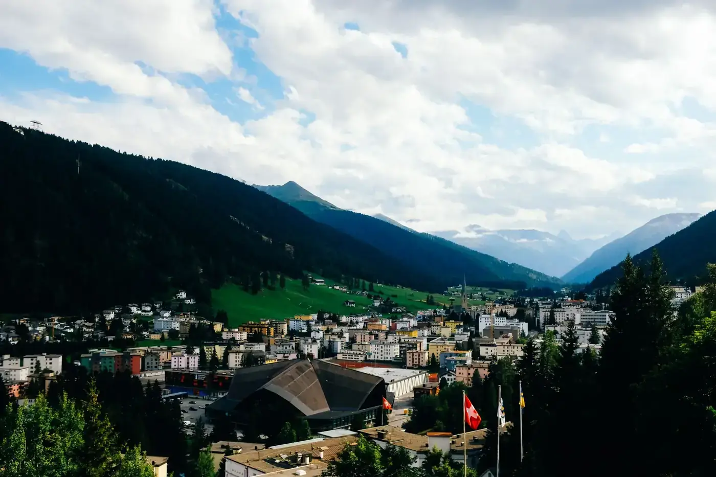 Captivating view of a Swiss town nestled in a lush valley surrounded by majestic mountains.