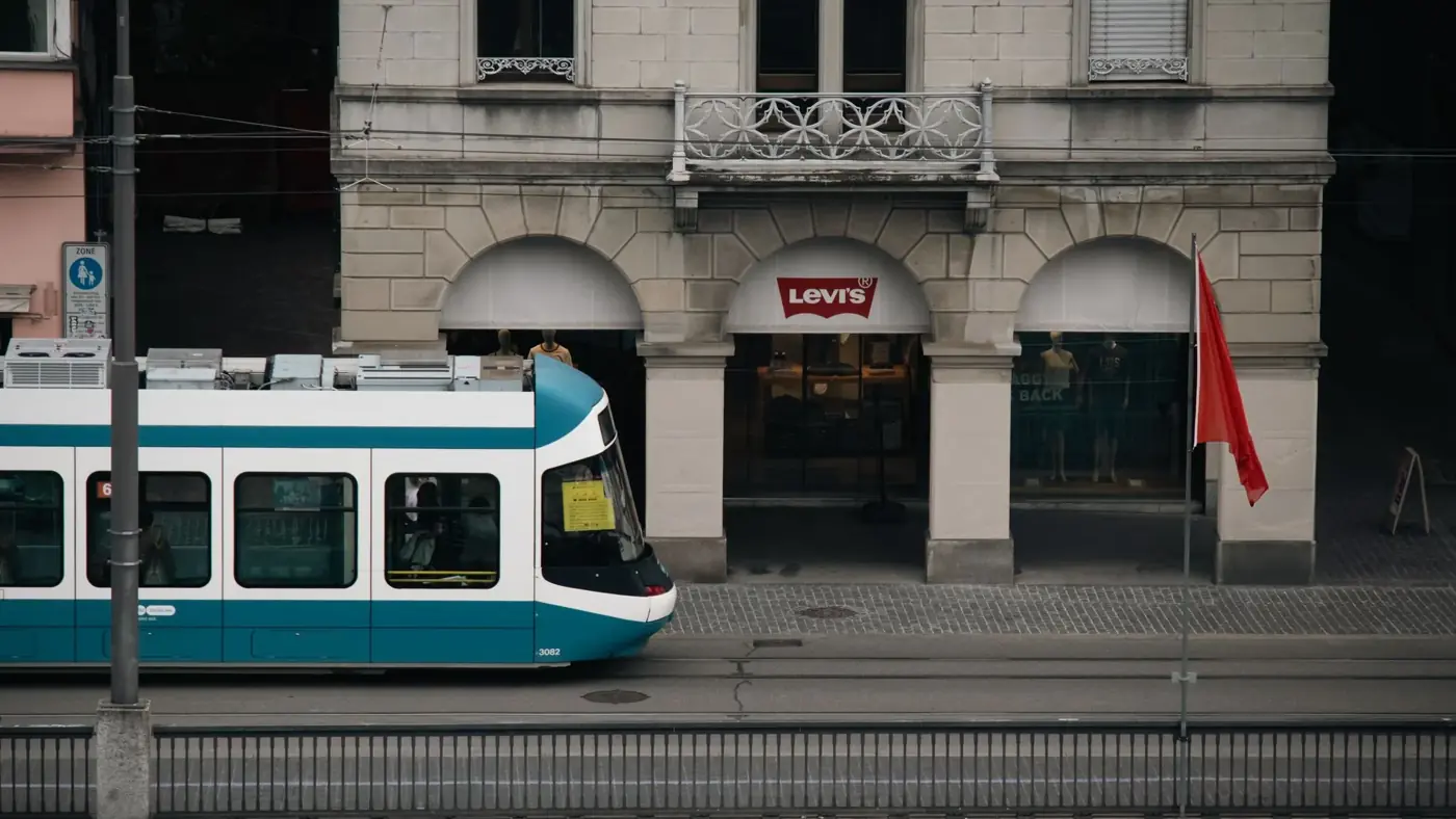 A tram passes by a Levi's store on a street in Zurich, capturing urban Swiss life.