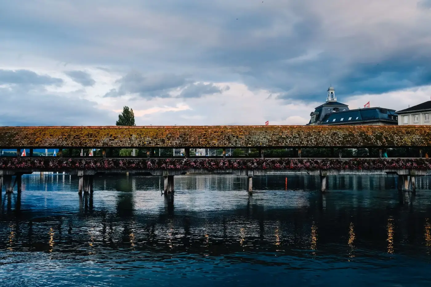 Explore the historic Chapel Bridge spanning the Reuss River in Lucerne, Switzerland.