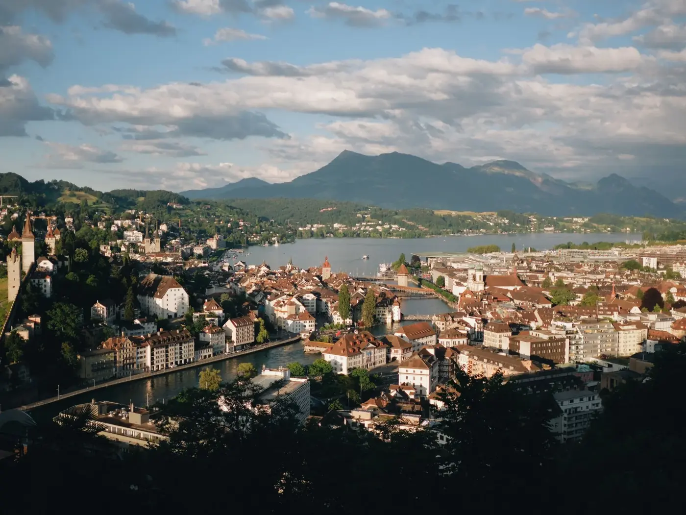 A picturesque aerial view of Lucerne, Switzerland featuring the cityscape, lake, and surrounding mountains.